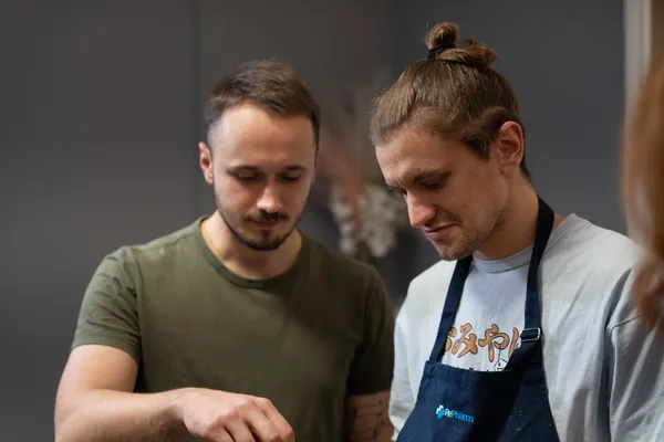 Divi dalībnieki kopā gatavo vakarā